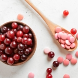 Spoon,With,Healthy,Cranberry,Pills,And,Berries,On,Light,Background,