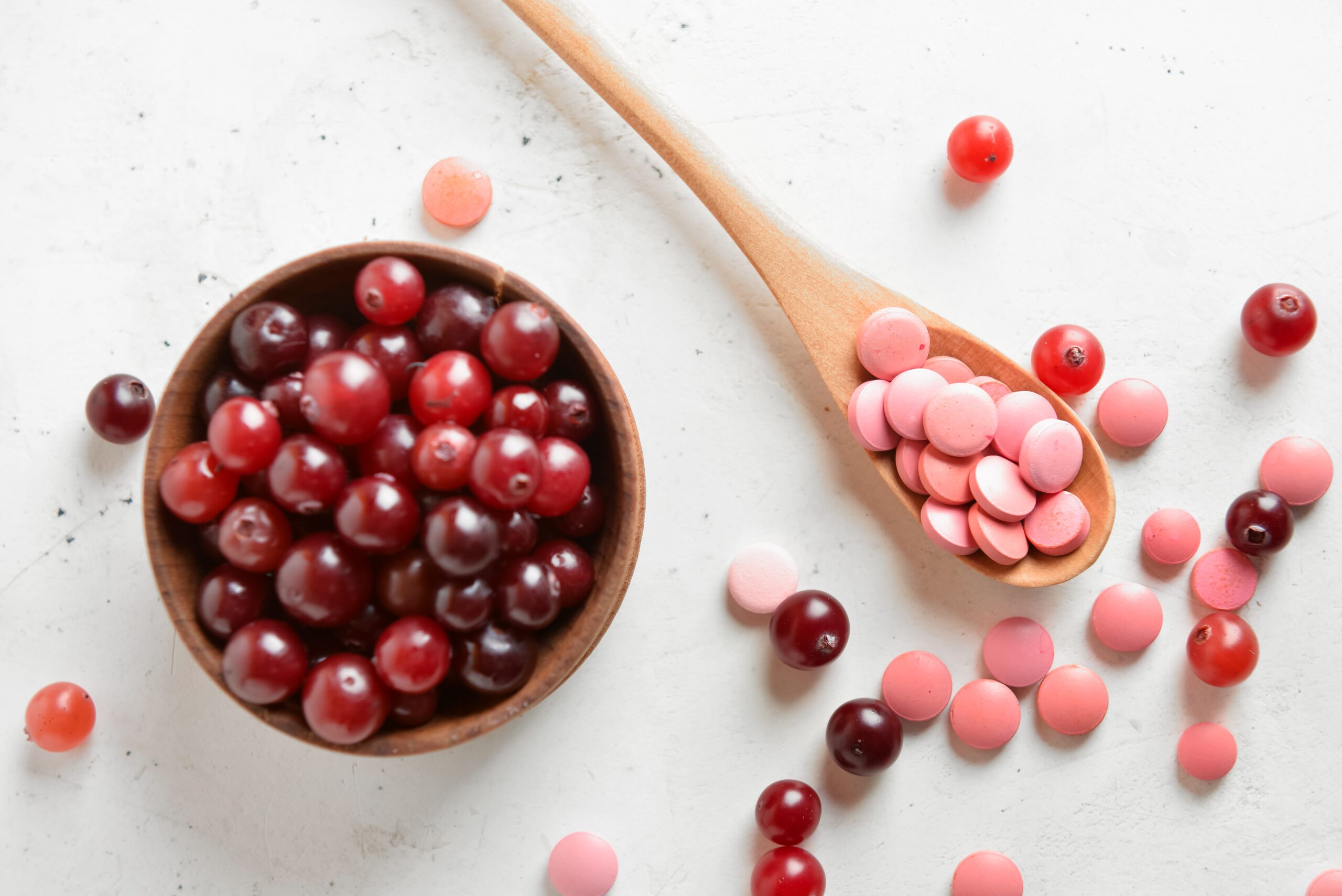 Spoon,With,Healthy,Cranberry,Pills,And,Berries,On,Light,Background,