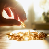 A,Man's,Hand,Reaching,For,Yellow,Transparent,Vitamin,D,And