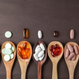 Assorted,Different,Pills,,Supplement,Vitamin,,In,A,Wooden,Spoon,On